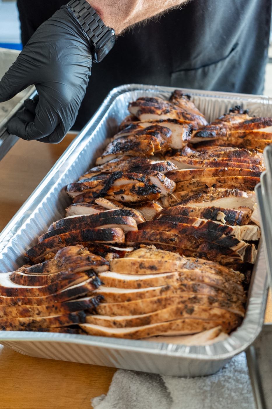 Tray of fresh-sliced live-fire grilled chicken