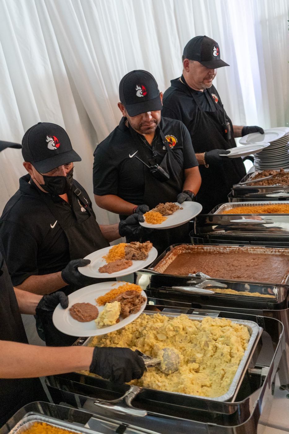 The Roosters crew plating food in branded gear