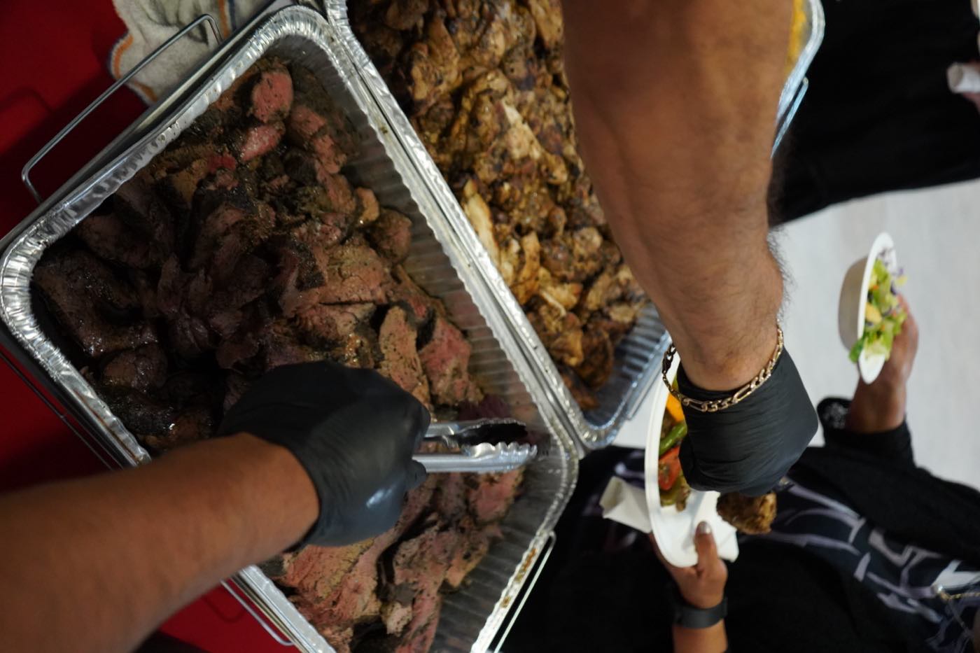 Serving carne asada and grilled chicken to a guest