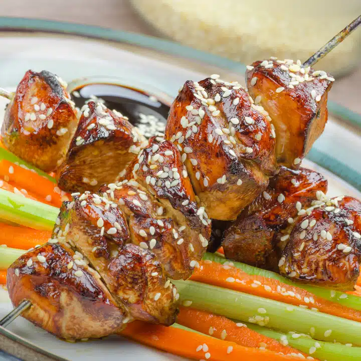 Sticky teriyaki chicken skewers with crunchy slaw - sprinkled with crunchy sesame seeds, Czech beer