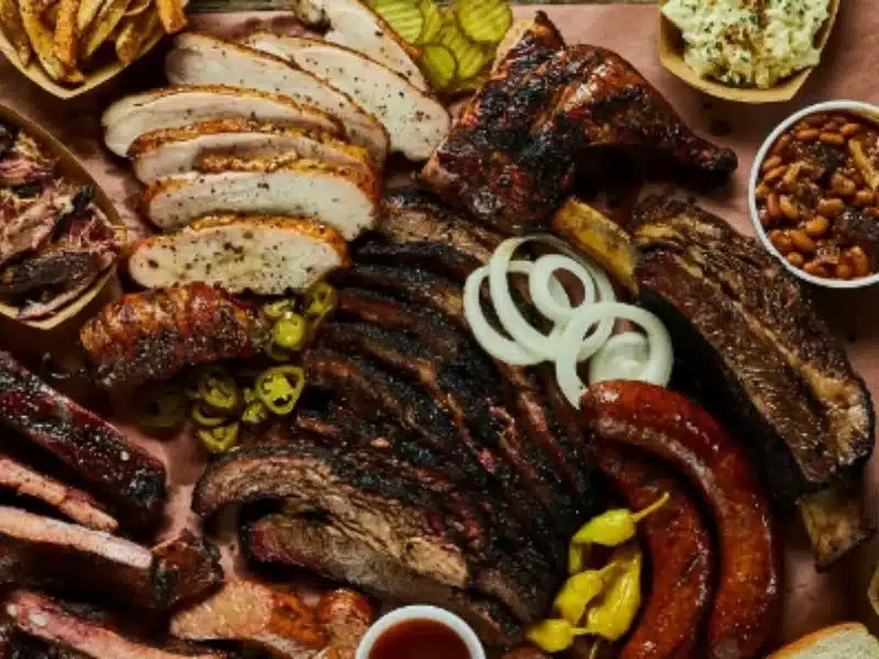 An image showing Rooster's Rolling BBQ catering service with a variety of BBQ dishes