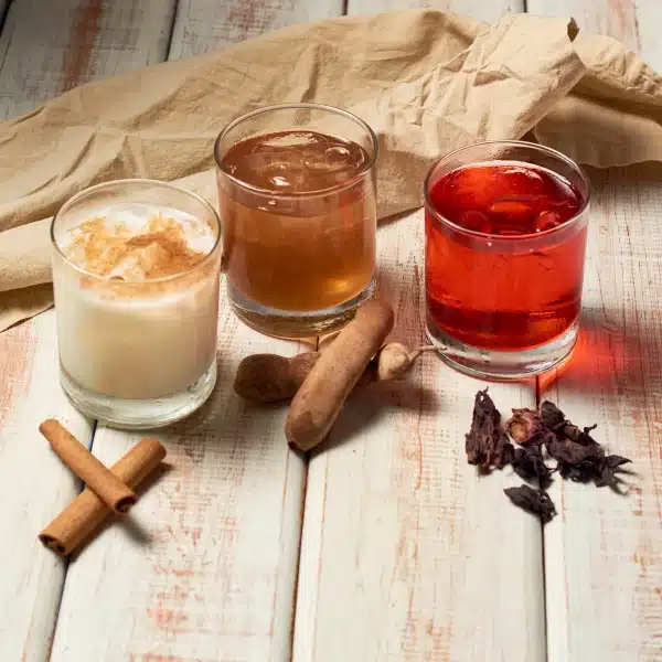 An image showing various traditional Mexican beverages including horchata, agua fresca, and limeade.